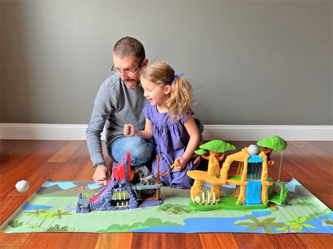Dad playing with daughter with dinosaur toys