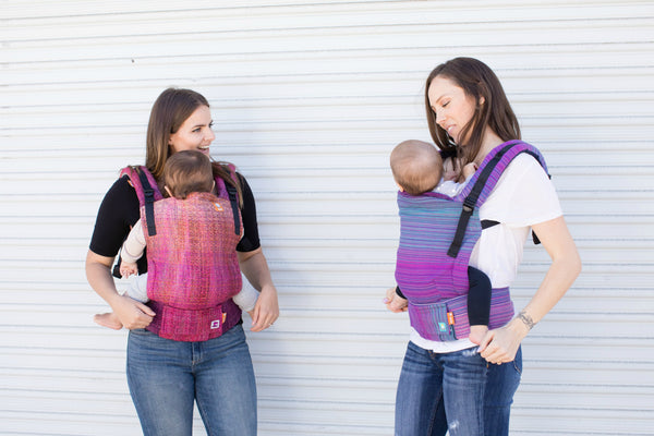 Two mothers, their children and their Signature Baby Carrier.