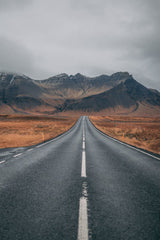 Empty two lane road heading toward mountains