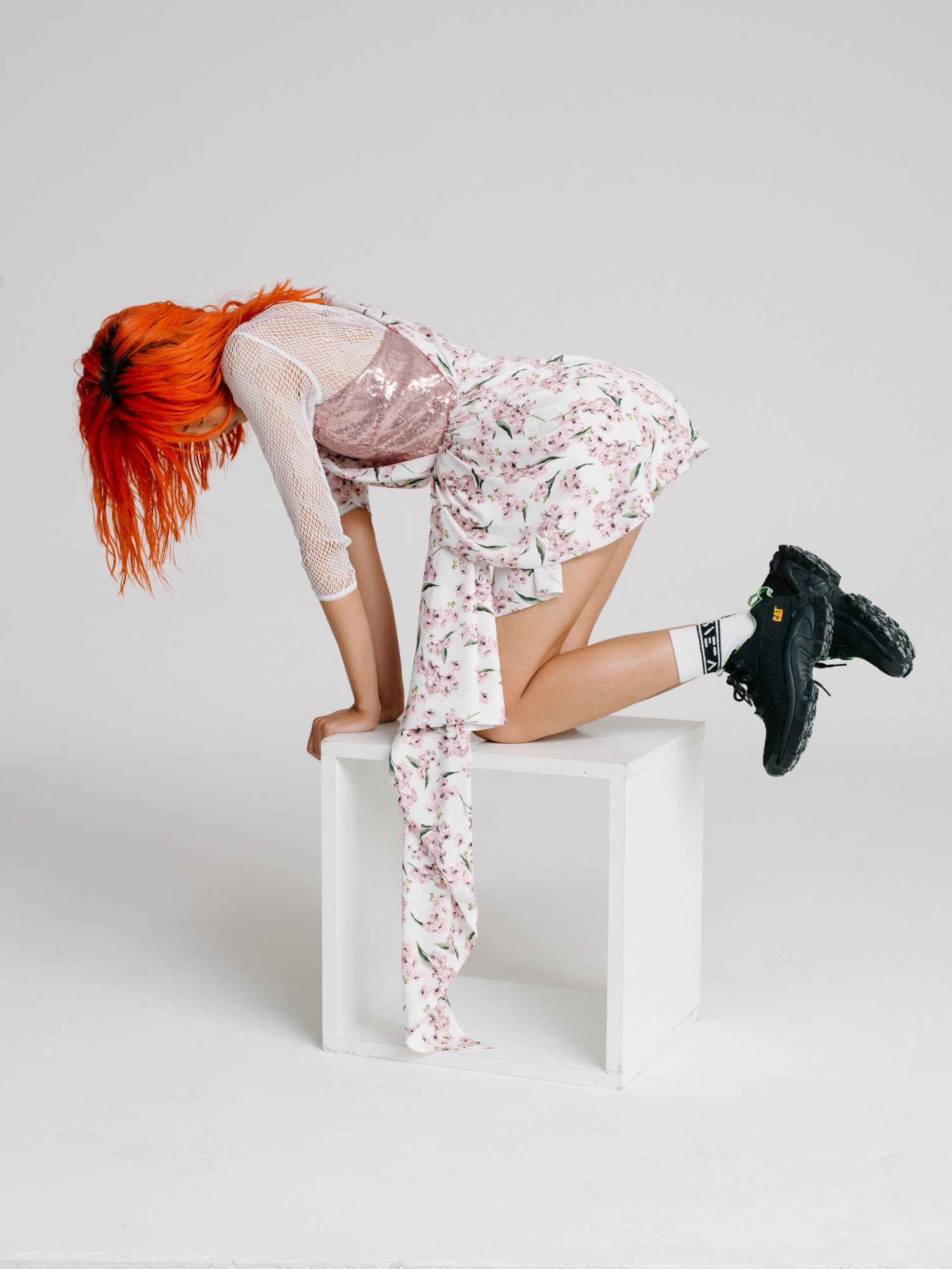 Red hair girl on a chair wearing a floral dress