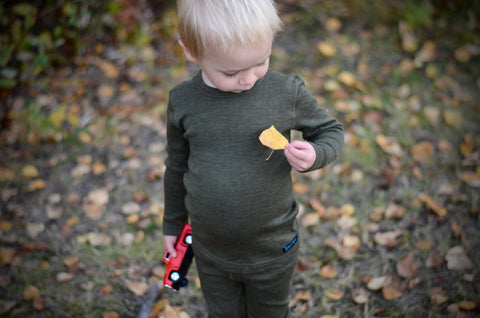 baby boy wearing green base layer with a yellow leaf on it