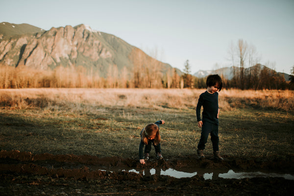 two kids wearing base layers playing on a field