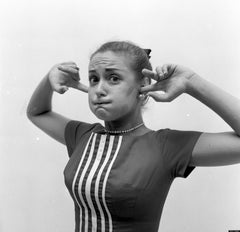 a lady in black and white covering her ears