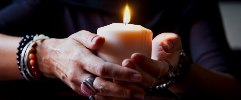 woman holding spiritual candle for blessing holistic skincare