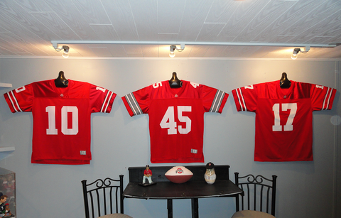 Ohio State Buckeyes football jerseys hanging on wall with JerseyGenius®