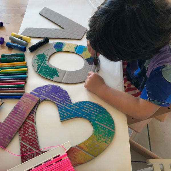 Child colouring in cardboard shapes