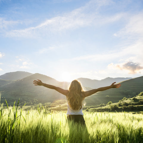Woman Feeling Joyful in a field with mountains | Find Your Purpose in Life