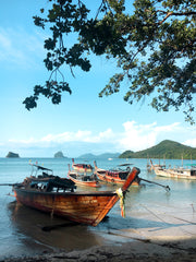 A beautiful and tranquil beach scene from Thailand with aqua water and longtail boats