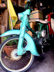 A vintage aqua motorbike in a garage in Thailand