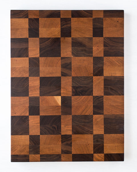 This gorgeous end grain cutting board features a rich and colorful combination of hardwoods that include cherry and walnut in a checkered pattern.