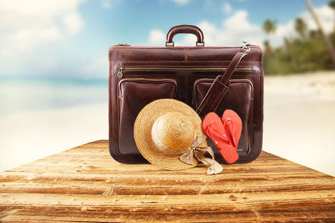 The Leather Garment Bag Sitting On The Beach With A Hat On Nice Sunny Day