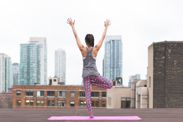 Woman doing yoga on a city rooftop