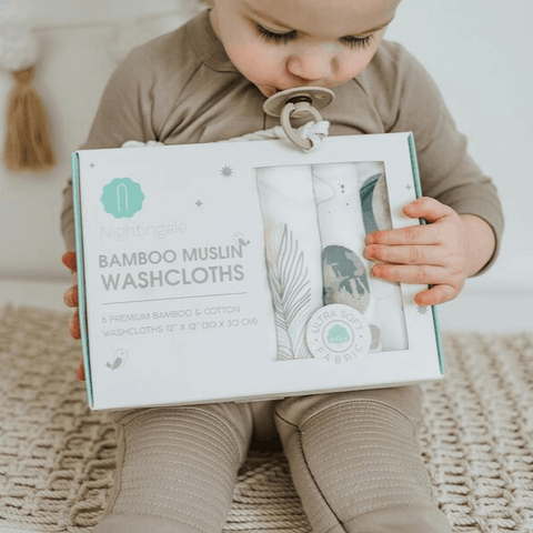 baby holding washcloths box