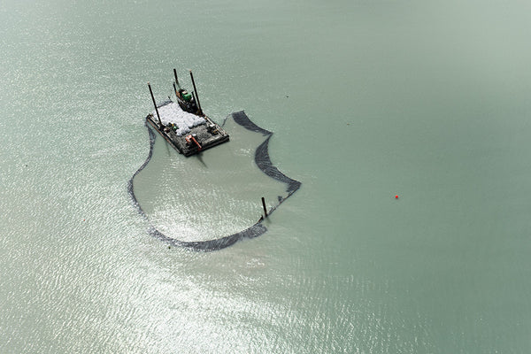 Large barge mining glacial oceanic clay in pristine ocean waters