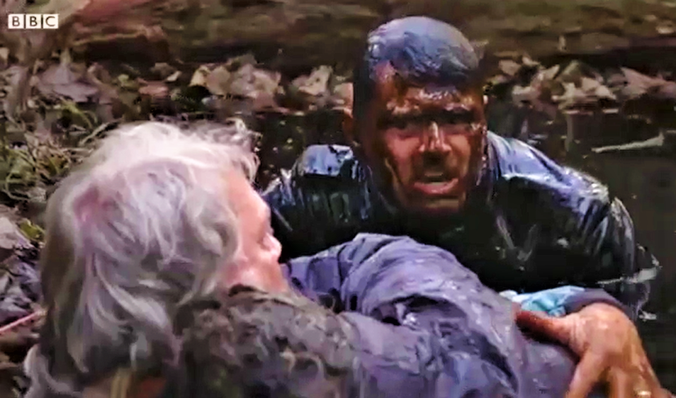 Ian from Casualty is rescuing someone from a huge mud pit