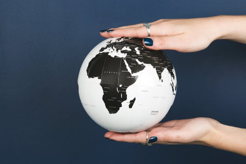 Hands holding a globe represents TwiLd Capit Hog accessories going global. Photo by Sarah Pflug from Burst