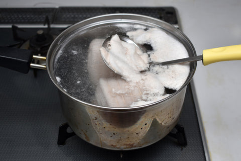 Skimming froth from pork chashu boil