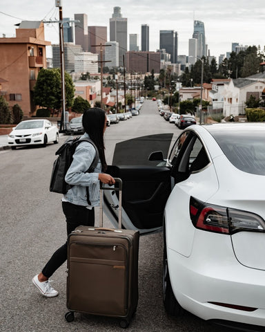 Woman entering car with luggage