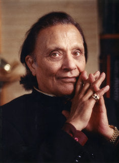 Image of Dr. Singha sitting, wearing a black outfit with his fingers intertwined