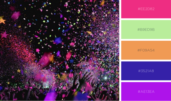 Magenta and other colors of confetti above a crowd of people at night