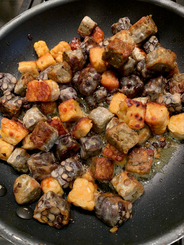different types of tempeh cooking together in a skillet