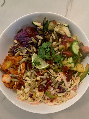 Summer BBQ Bowl layered with blue and purple potatoes, corn, spicy slaw, cilantro, and pepitas