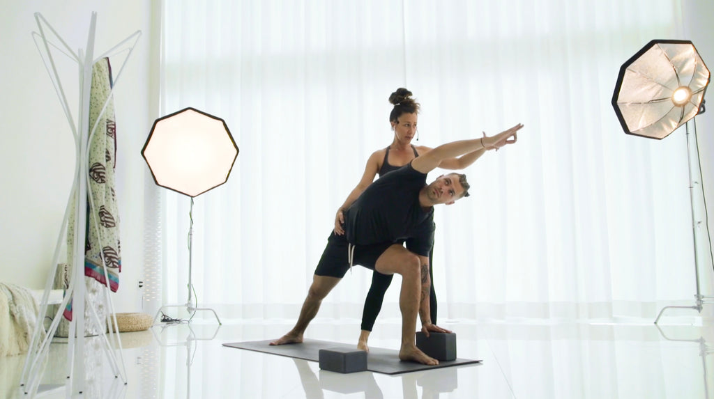 Yoga teacher and Ahana Yoga founder Dawn Feinberg, guides a student in a pose in their new virtual studio. 