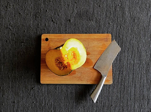 squash-pumpkin-kalabasa-slices-and-knife-on-wooden-bamboo-chopping-board