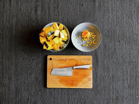 squash-pumpkin-kalabasa-slices-and seeds-in-bowls-and-knife-on-wooden-bamboo-chopping-board