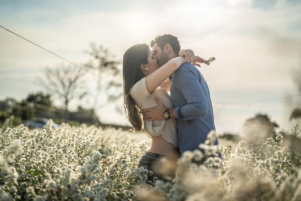 Romantic Couple kissing in a field of flowers