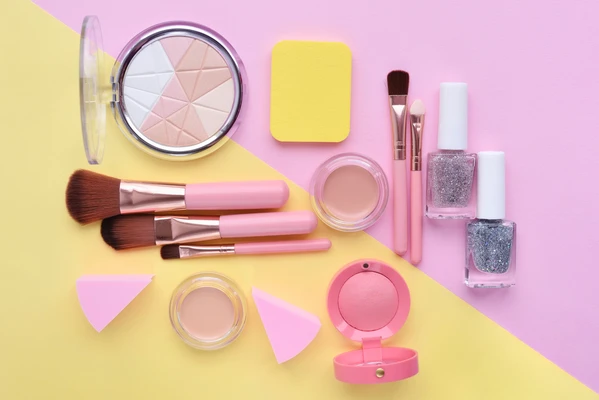 selection of makeup on a pink and yellow background