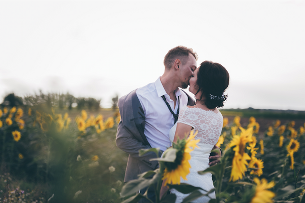 couple kissing in a sunflower field
