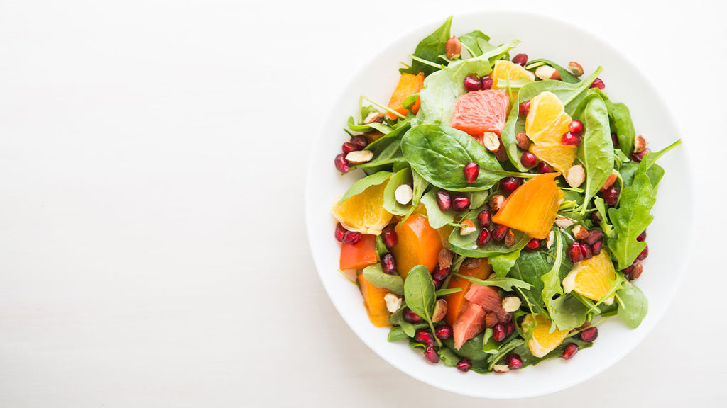 Crisp summery salad with pomegranate seeds, citrus, and persimmon.