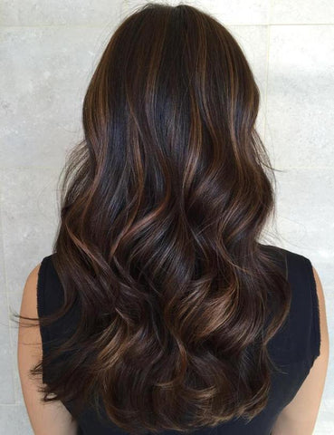 Natural dark hair enhanced with soft caramel highlights and lots of dimension 