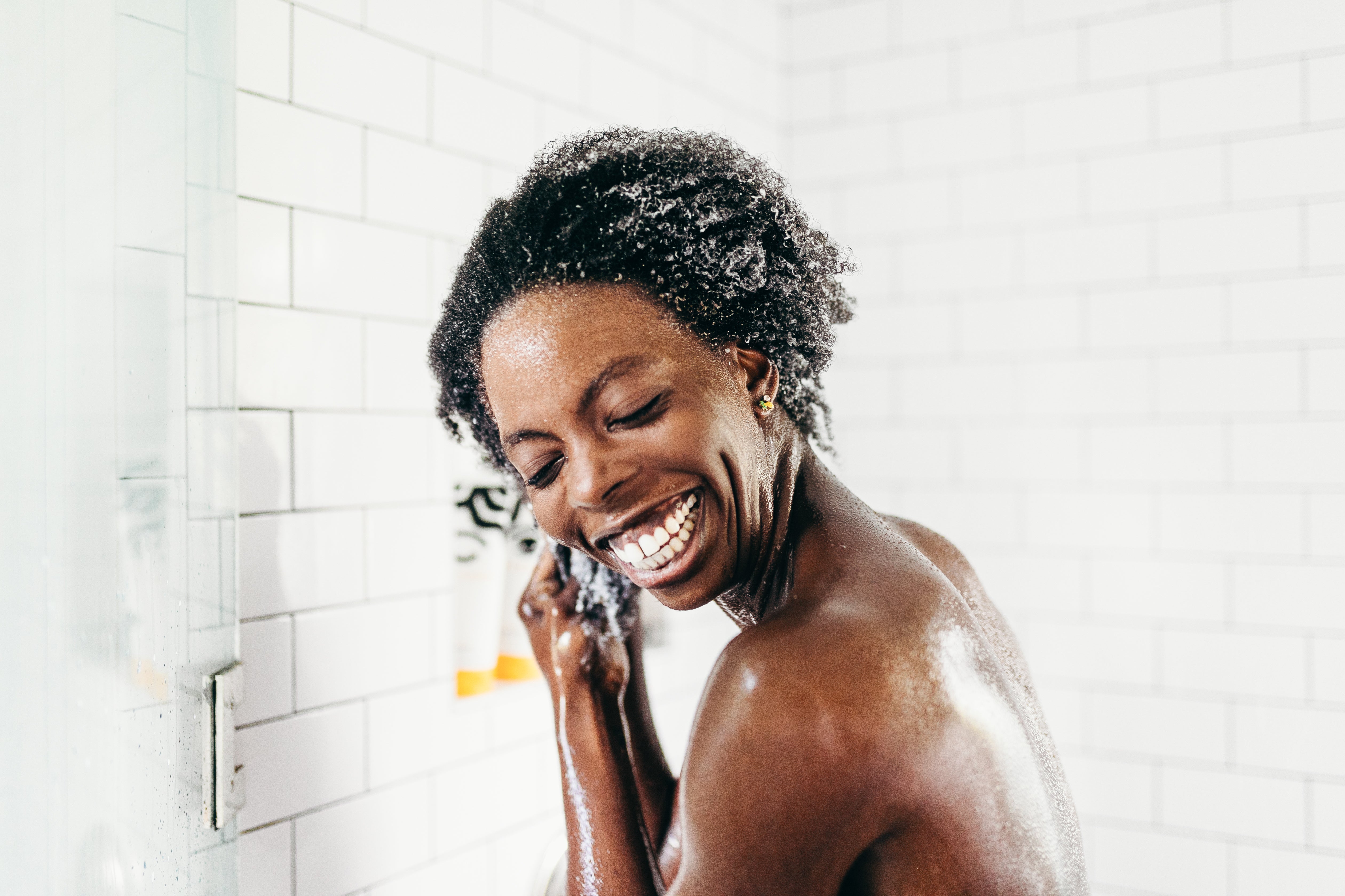 woman shampooing her hair in shower