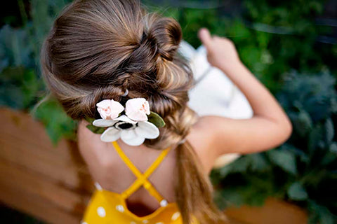 girl with flower in braided hair pouring a watering can OllieJay dress