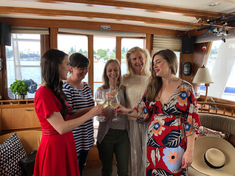 women clinking glasses of champagne on a vintage yacht