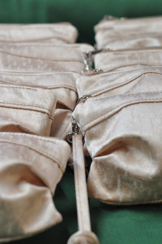 a row of ivory silk clutches for a wedding party bridesmaid gift