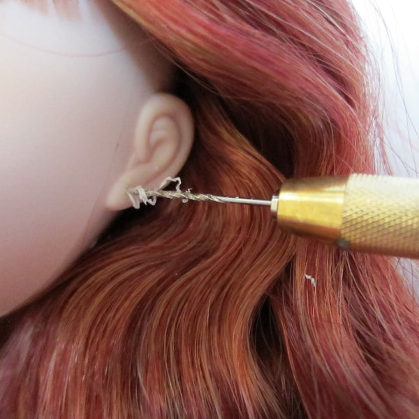 Drilling holes in Pullip doll's ears with hand drill