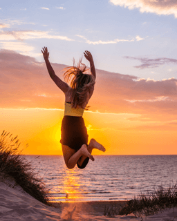 Woman jumping who had pain in her neck, back, or shoulder, pinched nerves, soreness, cervical neck spasms, herniated discs and tension that was helped with a neck decompression traction device for at home pain therapy.