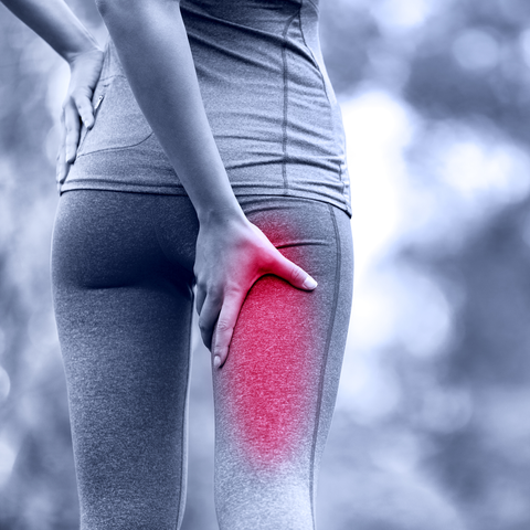 A woman experiencing the pain of sciatica in need of hip joint support brace.