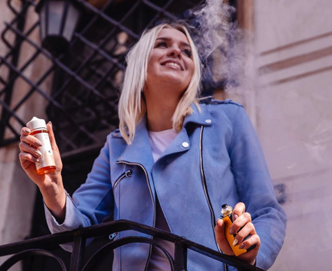 Woman on balcony using vape and e-liquid while on business trip