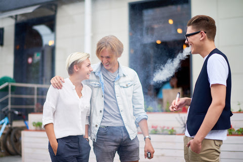 three friends outside vaping and talking