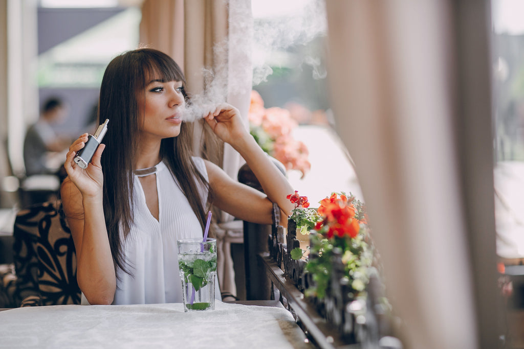 woman vaping in a cafe