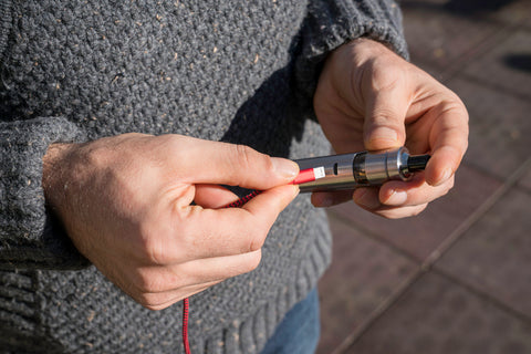 man charging electronic cigarette vape pen