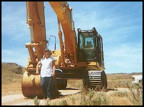 Bev standing next to an excavator