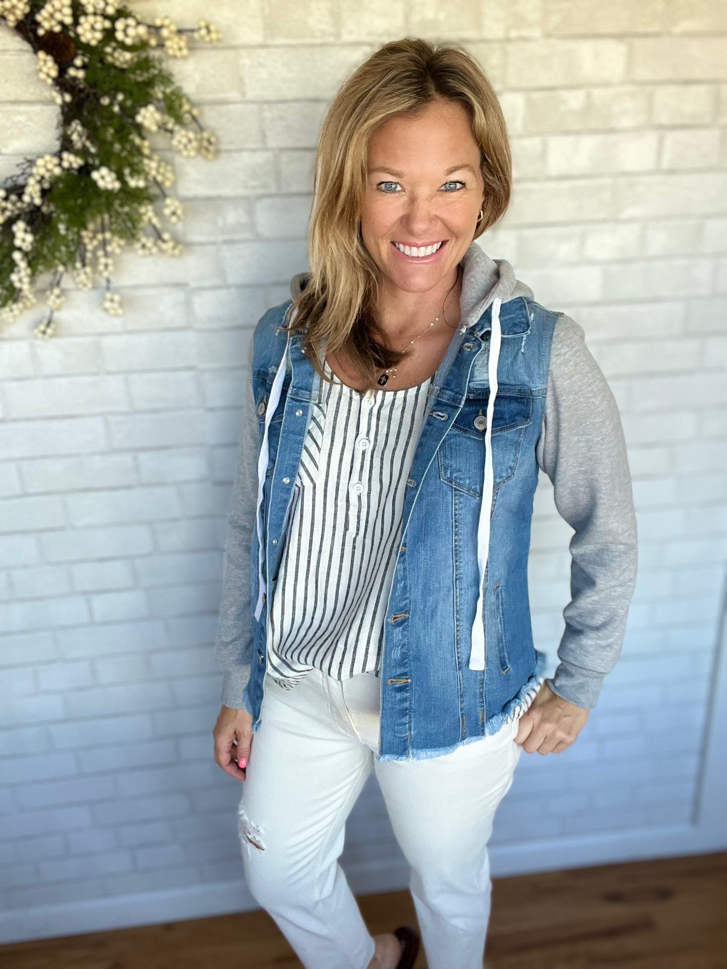 A stretchy jean jacket with detatchable hoodie. Hits about mid hip, but still has a slimming fit. Raw hem on the bottom with distressing on the shoulders. Buttons down the front with pockets on the side. Christy is wearing a small. LENGTH: 23.5" COTTON 98% SPANDEX 2%