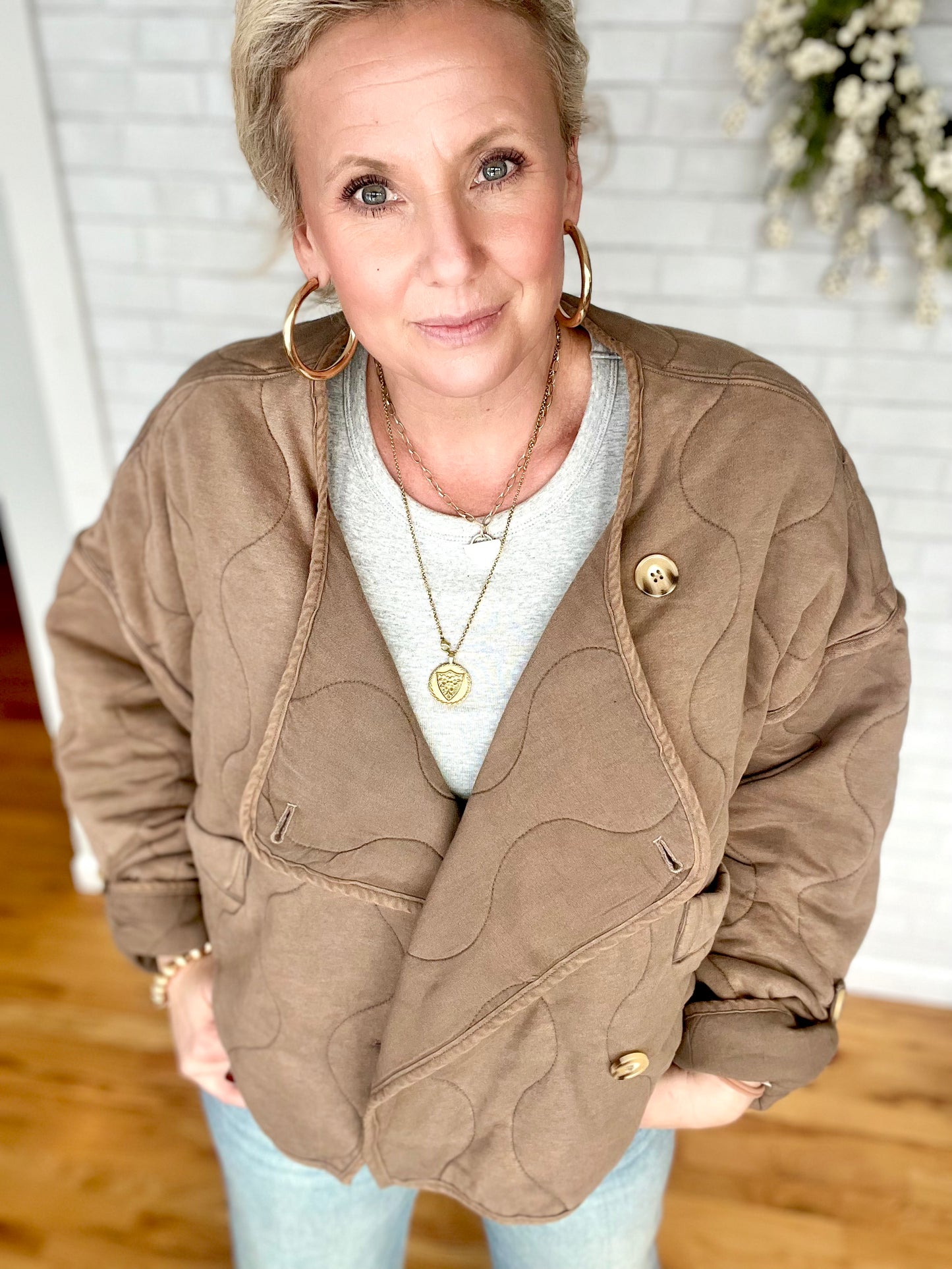 A quilted jacket that has a washed look to it. A drop shoulder and buttons up the front that are asymmetrical. You can cuff the sleeves for a different look. Fit is true to size.