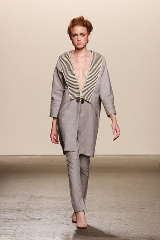 Look 23: Theresa, Lineas Coat in stone organic cotton with hand-loomed pima cotton and alpaca textile, Mapuche handmade artisanal broche and buttons, Razer Pants in stone cotton