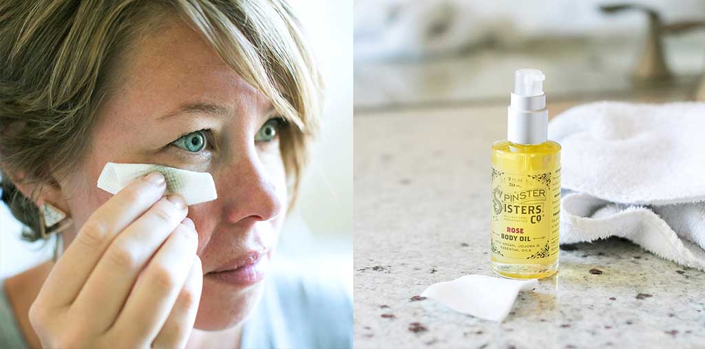 A woman uses Body Oil to wipe away makeup with a tissue